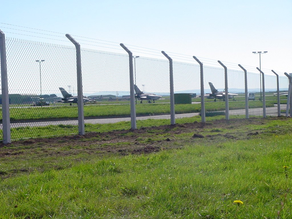 Chainlink supported on concrete posts securing a fuel bunker within an MOD site.