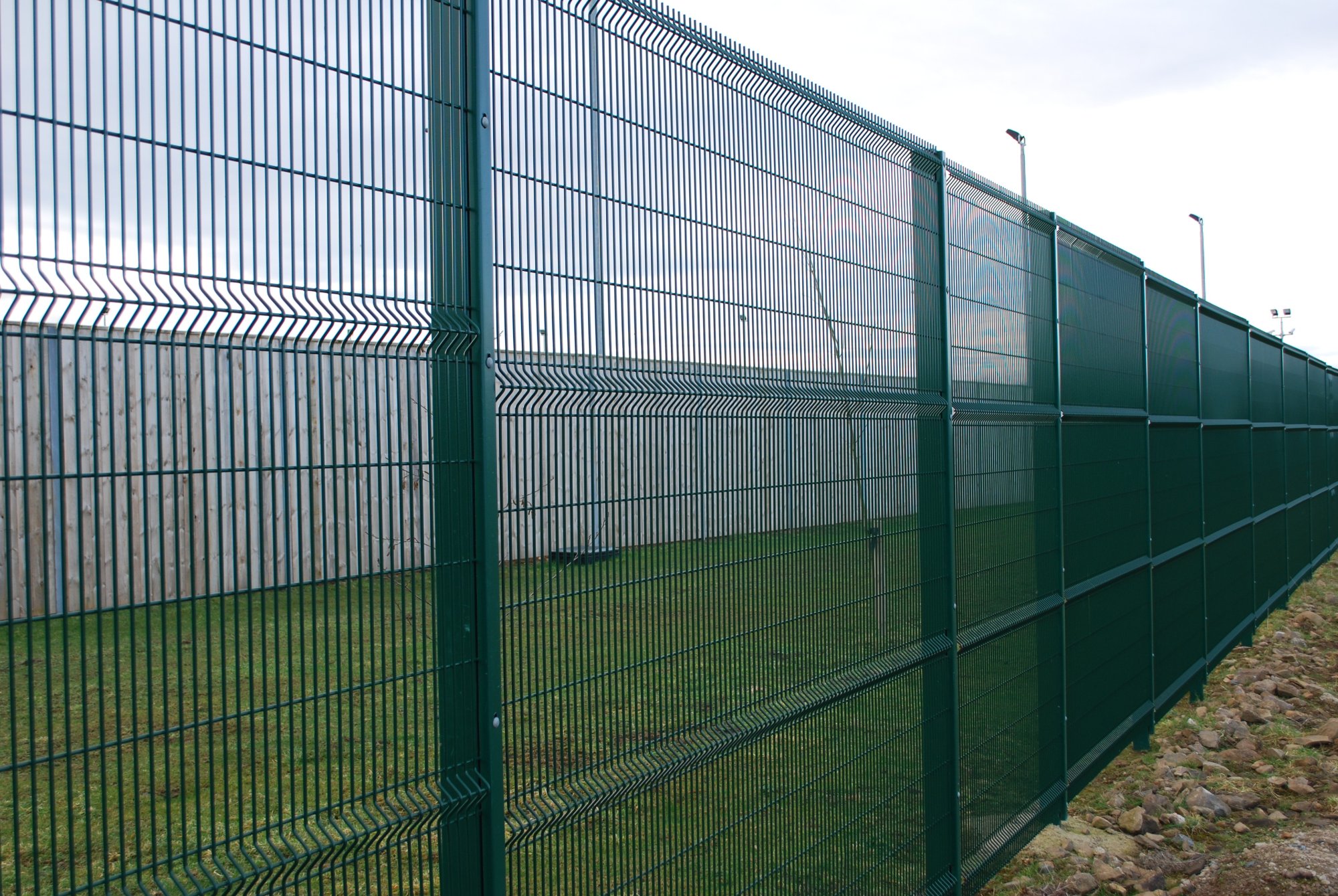 Ultimate Extra security fencing panel. This panel is formed in 6mm diameter wire with a mesh size of 165x25mm. Horizontal profiles provide rigidity to the panel. We also supplied and installed the acoustic fencing seen in the background.