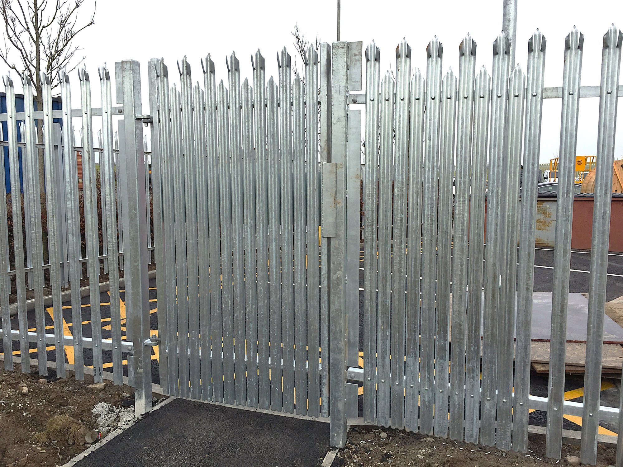 A single leaf escape gate intalled within a standard 1800mm high palisade fence. Additional pales are added to prevent external access to the exit push pad.